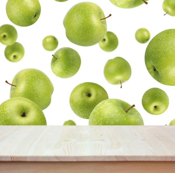 Mesa de madera vacía sobre fondo de manzanas verdes voladoras . —  Fotos de Stock