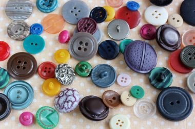 Dağınık, çok renkli plastik butonlar yukarıdan görünüm.