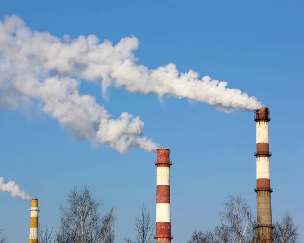 Factory pipes with smoke against blue skies. — Stock Photo, Image