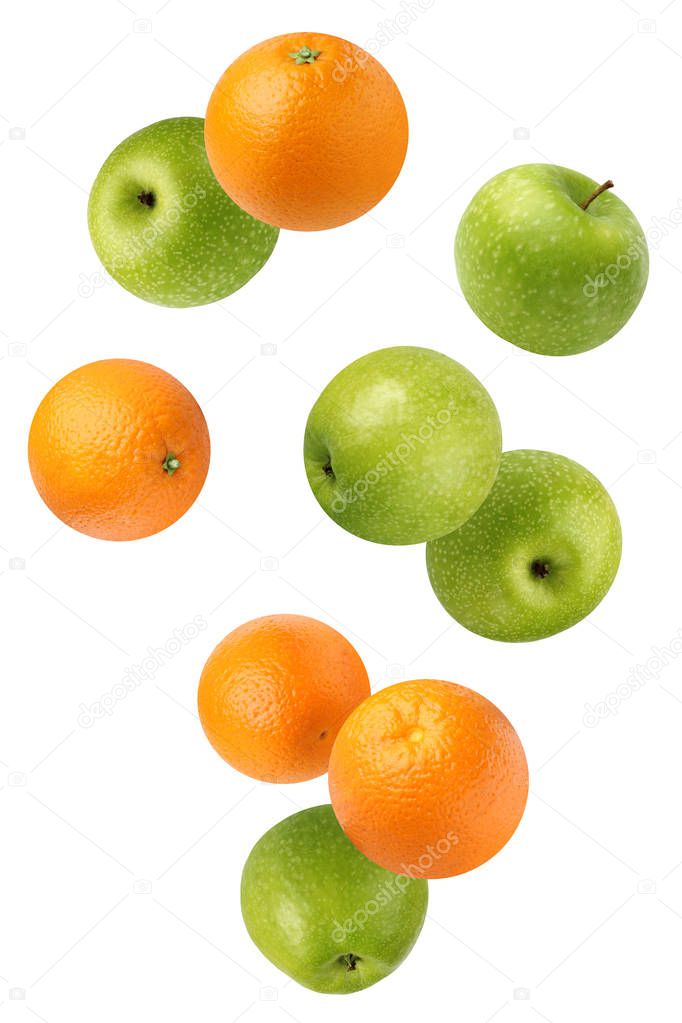 Flying green apples and oranges, isolated on white.