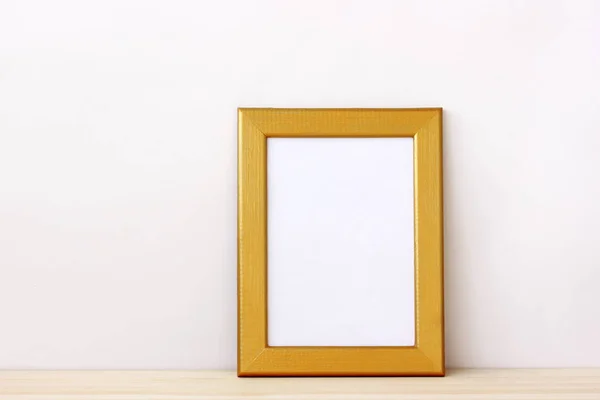 Empty frame for photo on the table on a light background.