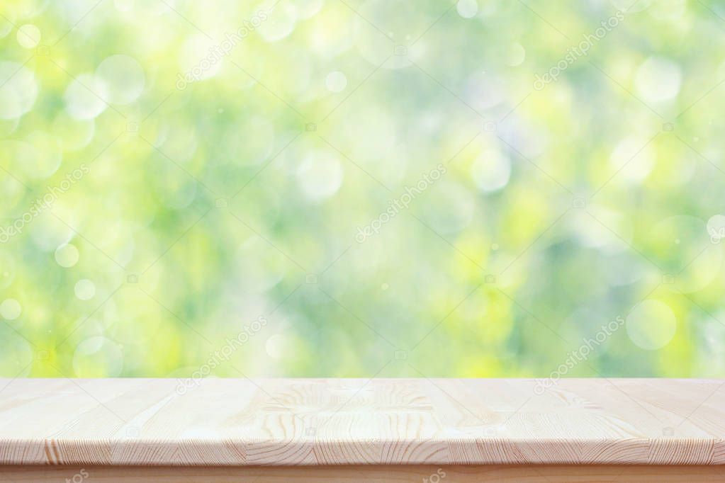 Empty wooden countertop on blurred spring background with bokeh.