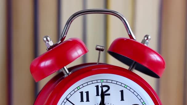 時計に手が近づいています 深夜は 本の背景をぼかしの赤の古典的な目覚まし時計 新しい年 — ストック動画