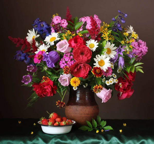 Stillleben mit einem Strauß Gartenblumen und reifer Erdbeere — Stockfoto