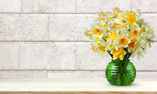 Bouquet of yellow daffodils on a light background of a wall of b — Stock Photo, Image