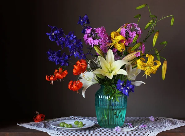 Strauß von Gartenblumen in einer Glasvase. — Stockfoto