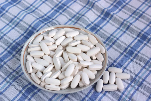 Large white pills on a plate. — Stock Photo, Image