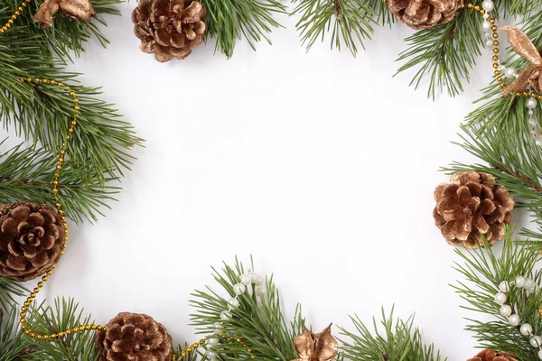 Weihnachtskulisse mit Tannenzweigen und Zapfen auf weißem Grund — Stockfoto