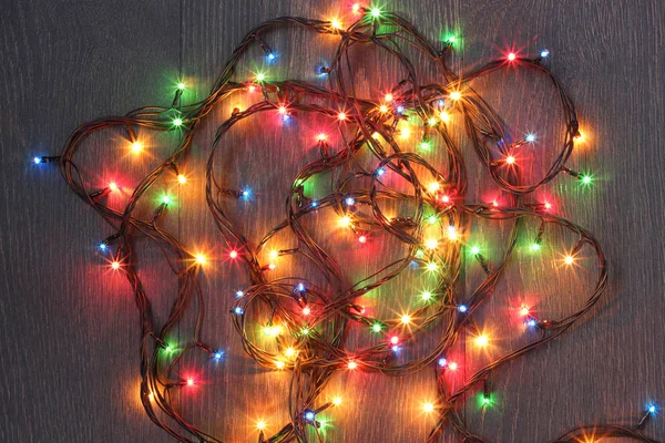 Electric colorful garland on a dark background, top view. — Stock Photo, Image