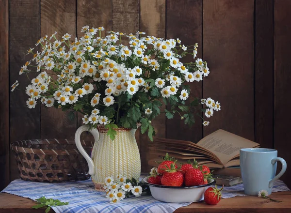 Naturaleza muerta con un ramo de margaritas y fresas maduras en un —  Fotos de Stock