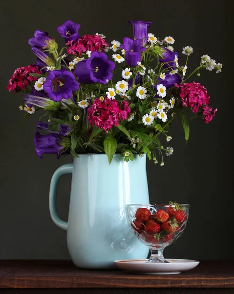 Modest bouquet of garden flowers in an enameled blue jug — Stock Photo, Image