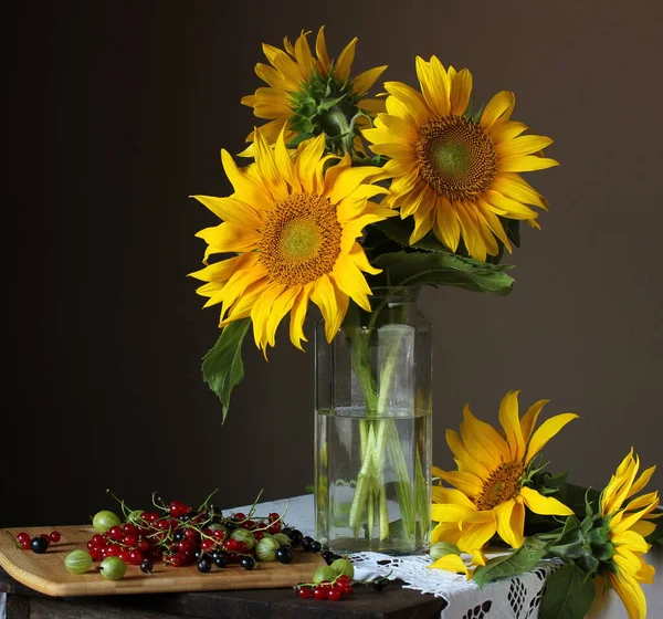 Sunflowers in a glass jar and garden berries: currants and goose — ストック写真