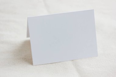 Modelleme, beyaz karton bir şablon ve hafif bir tekstil arkaplanı. Seçici odaklanma. Metnin ya da resmin için boşluk.