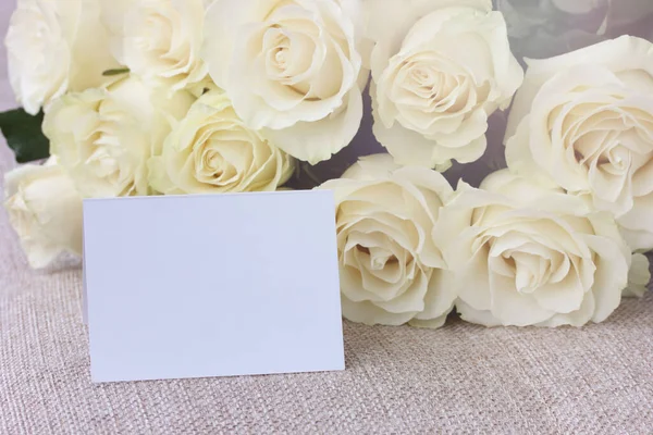 Μπουκέτο Λευκά Τριαντάφυλλα Και Μια Λευκή Κάρτα Τραχιά Υφασμάτινη Επιφάνεια — Φωτογραφία Αρχείου