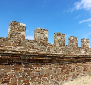 Taş ve mavi gökyüzünden yapılmış siperleri olan klasik bir duvar. ilginç bir yer, antik mimari.