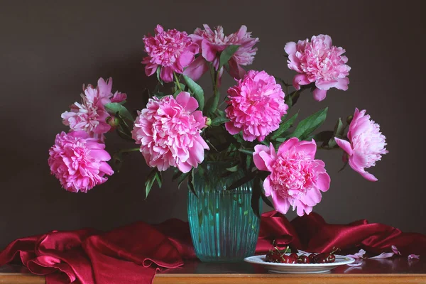 ガラスの花瓶や皿の上の桜のピンクの庭の牡丹の豪華な花束 まだ花や果実と共に生きる — ストック写真