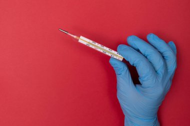 Kırmızı arka planda termometre var. Yalıtkan. Sağlık konusu