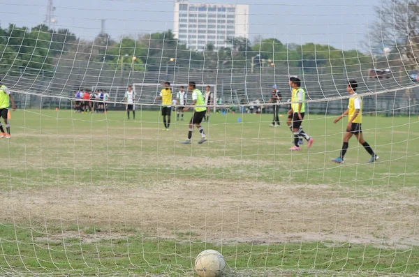 少年たちはサッカー場でサッカーをしている 写真はサッカーのゴールの後ろに捉えられている — ストック写真