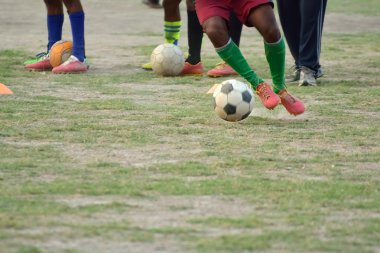 Futbol topu tekmelemek için çalışıyor