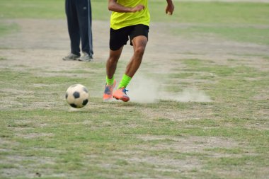 Futbol topu tekmelemek için çalışıyor