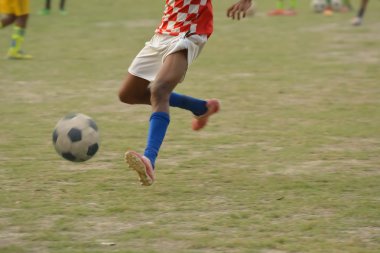 Çocuk futbol oynuyor.