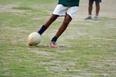 Çocuk futbol oynuyor.