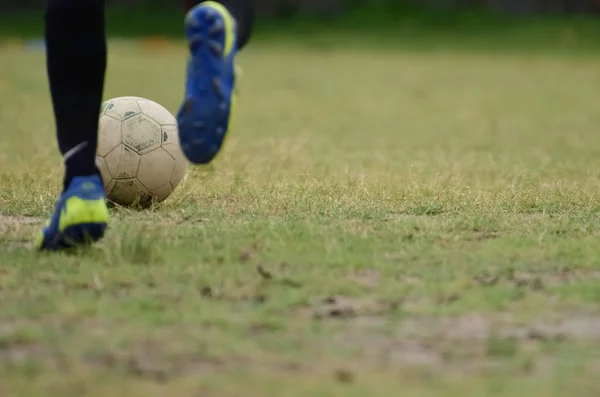 Soccer player is running to kick soccer ball.