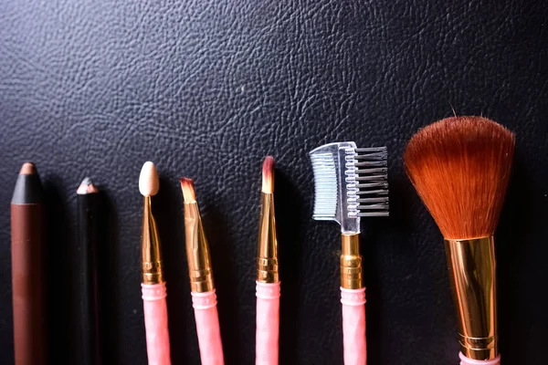 Makeup brushes on leather background