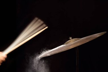 Müzisyen davul palet siyah arka plan üzerine vuruyor