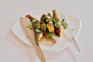 Gri arka plan üzerinde beyaz plaka üzerinde ızgara balık 