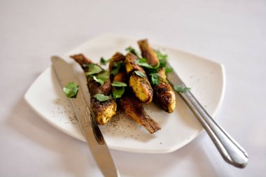 Gri arka plan üzerinde beyaz plaka üzerinde ızgara balık 