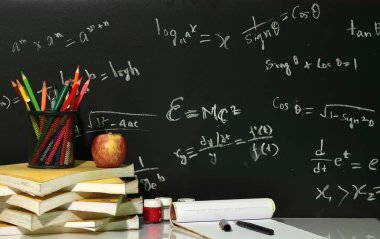 Kitap yazı tahtası Matematiksel denklemler karşı masada dizilir