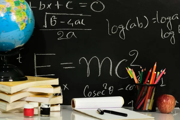 Kitap yazı tahtası Matematiksel denklemler karşı masada dizilir