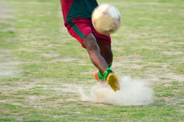 Soccer player is kicking ball during football practice in field