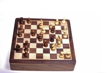 Satranç tahtasındaki satranç taşlarının üst açısıyla beyaz arka plan karşı karşıya. Tahta satranç taşları.