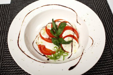 domates ve mozzarella ile fesleğen yaprakları bir plaka üzerinde