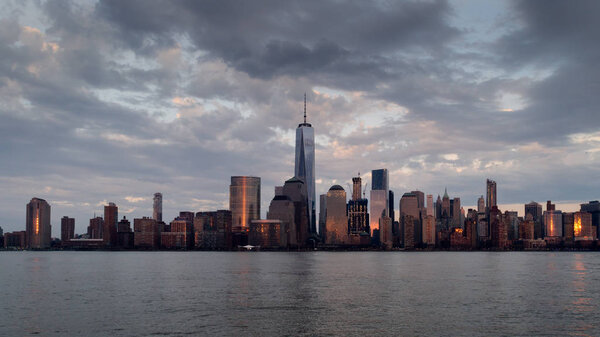 Panoramic view of Manhattan skyline with its reflection in Hudson river at dusk from New Jersey pier. New York, USA