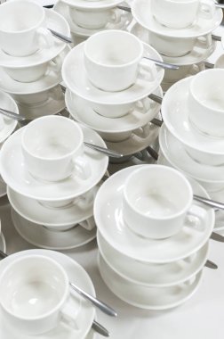 Temiz beyaz bardak ve tabaklar satırlar ve bir diğerinde setleri