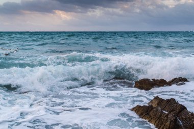 Köpük, dalgalar ve alacakaranlıkta bulutlu gökyüzü dramatik fırtınalı Deniz Manzaralı