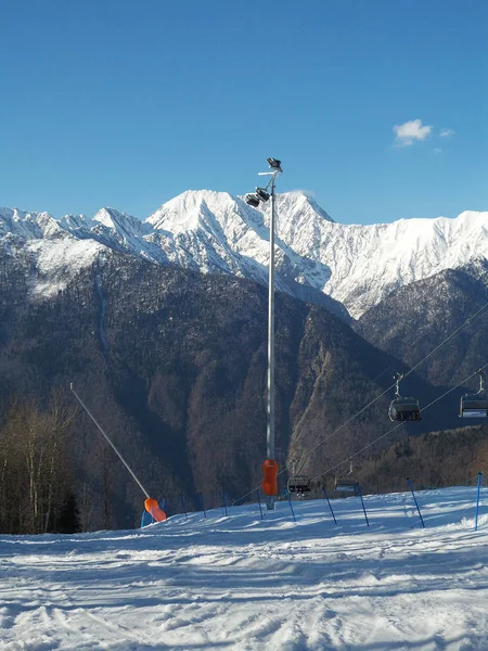 Montañas cubiertas de nieve, pista de esquí y cable —  Fotos de Stock