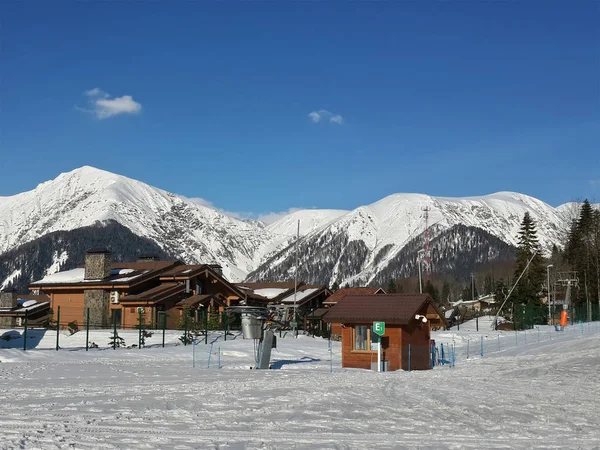 Χιονισμένα βουνά και ξύλινα σπίτια, σκι θέρετρο Κράσναγια Πολιάνα, Ρωσία — Φωτογραφία Αρχείου