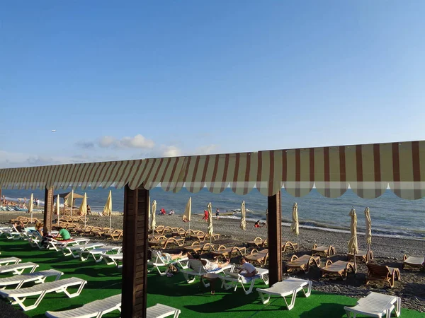 Filas de tumbonas bajo toldo en la playa de mar — Foto de Stock