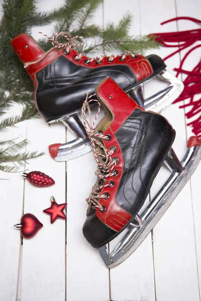 Christmas card - vintage skates in the New Year decor - fir branch, red scarf, toys
