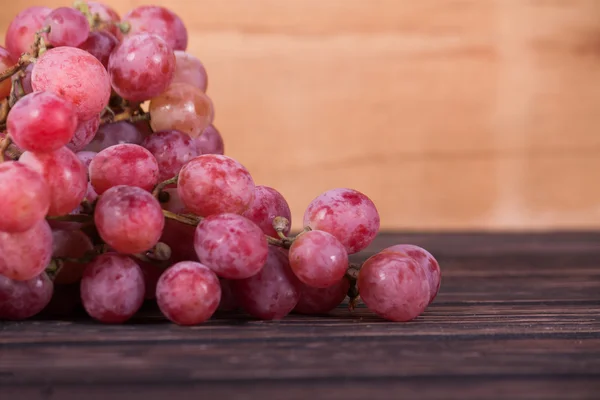 Uvas vermelhas em madeira — Fotografia de Stock