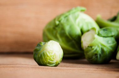 Ahşap tahta üzerinde olgunlaşmış taze Brüksel lahanası. 