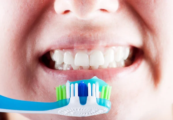 Nova escova de dentes no fundo da pessoa — Fotografia de Stock