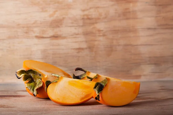 Ripe fresh persimmon on wood board — Stock Photo, Image