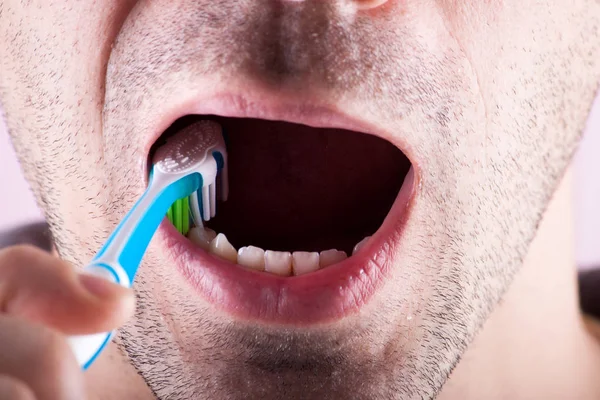 Nuevo cepillo de dientes en el fondo de la persona . Imagen De Stock