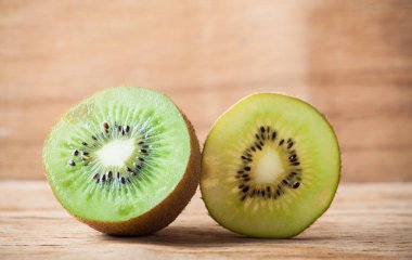 Ahşap masanın üzerinde izole olgun taze kivi.