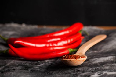 Kaşık biber ve grunge koyu arka plan üzerinde taze biber baharat ile
